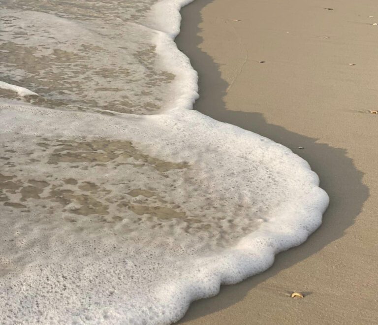 Close up shot of ocean water coming on the beach